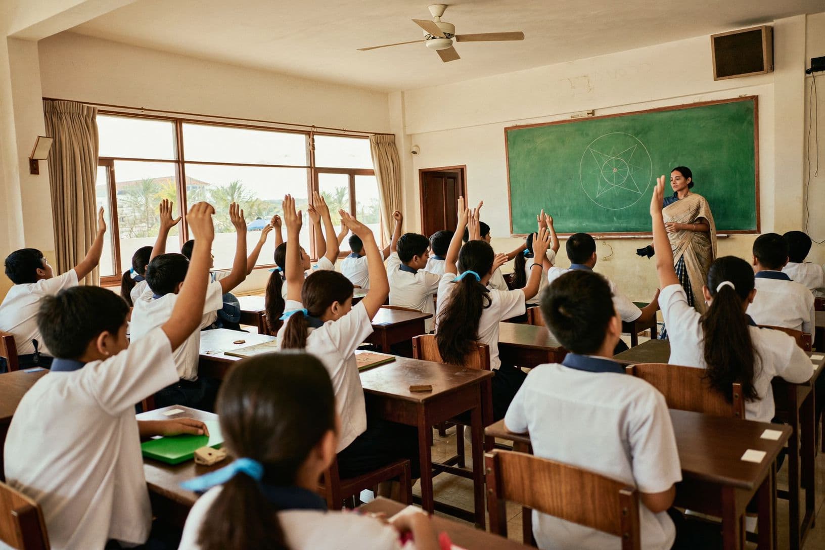 A classroom in session, hands raised